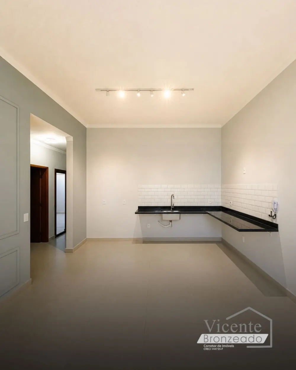 Cozinha integrada com bancada em granito preto e revestimento branco tipo metrô